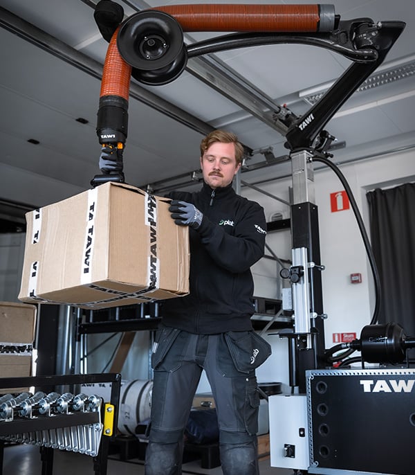 A person lifts a box with TAWI's mobile high frequency lifter.