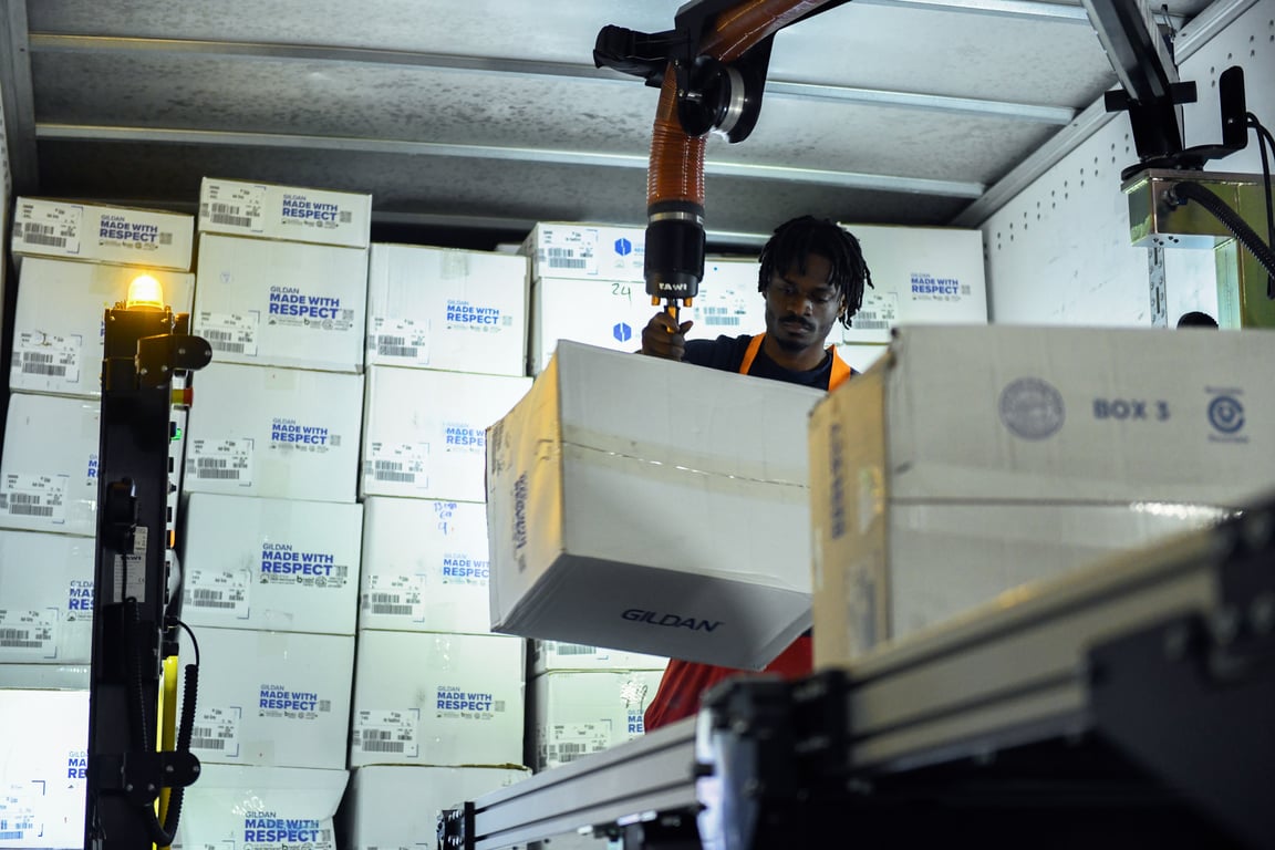 Person uses TAWI Container Unloader to handle boxes in a truck