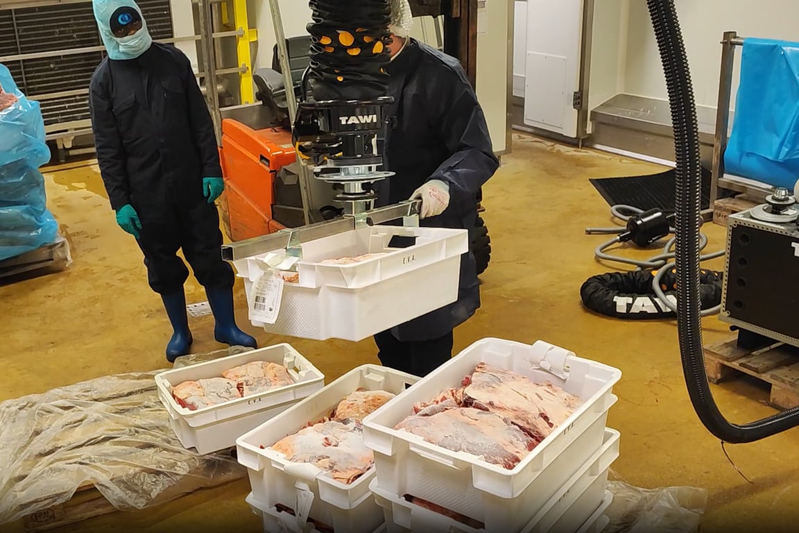 Opérateur levant un bac agroalimentaire avec un manipulateur TAWI
