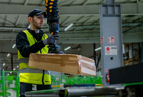 Paket lyfts med vakuumlyft på Brings lager