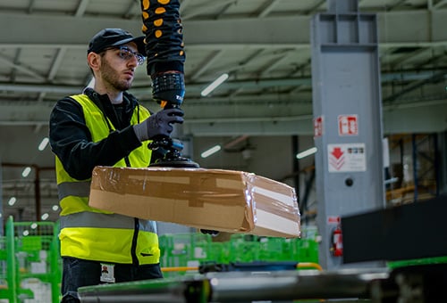 Paket lyfts med vakuumlyft på Brings lager