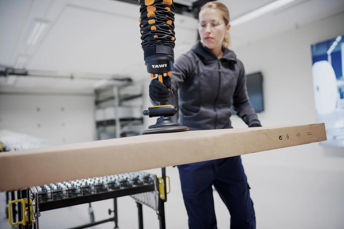 Woman lifting large box with TAWI vacuum lifter