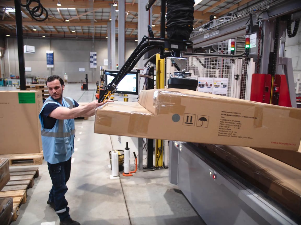 El elevador por vacío levanta una caja grande.