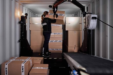 Female worker unloading a shipping container with TAWI Container Unloader