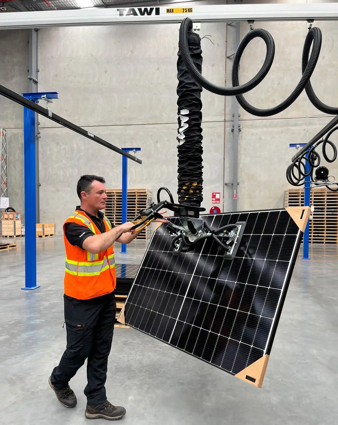 Opérateur manipulant un panneau solaire à l'aide d'une solution de levage ergonomique TAWI