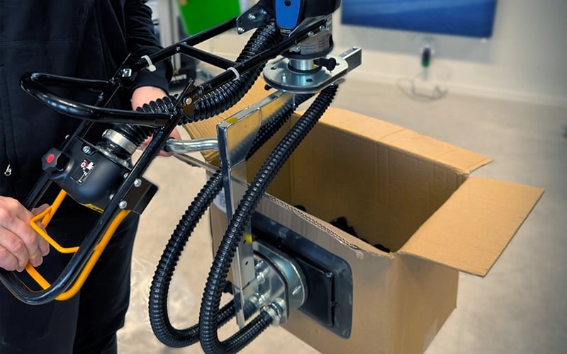 Öppna kartonger lyfts med en vakuumlyft från TAWI