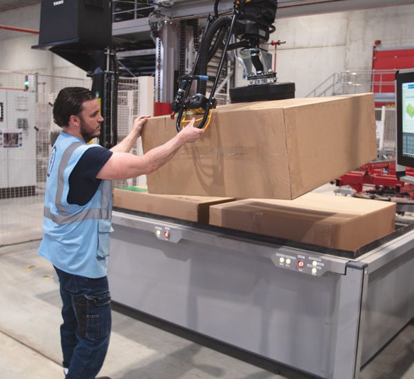 TAWI box lifter in action on the warehouse floor. Effortlessly lifting heavy boxes, taking the strain off the worker.