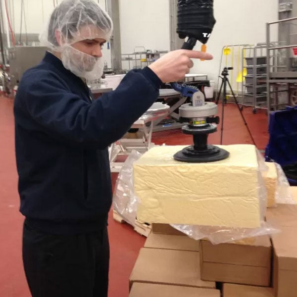 Dairy Products being lifted with a vacuum lifter, raw block of cheese