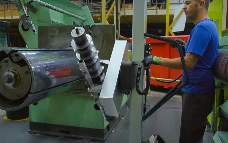 Man lyfter metallkomponent med elektrisk lyftvagn