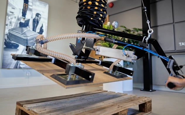 Manipulador de tableros manejando una plancha de madera