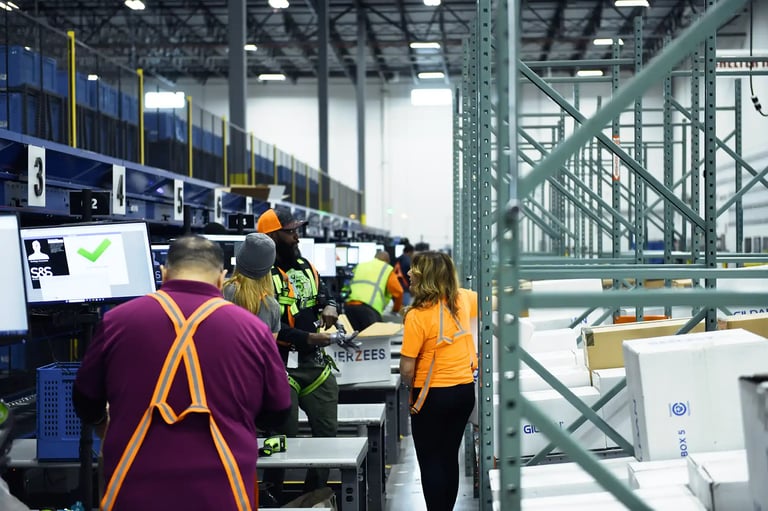 Warehouse workers at S&S Activewear manually handling heavy boxes