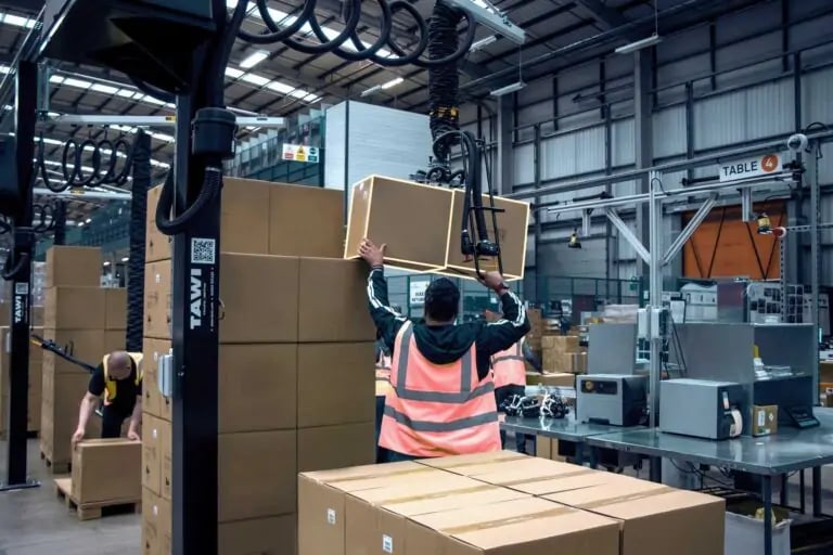 A man handling boxes with a vacuum lifter