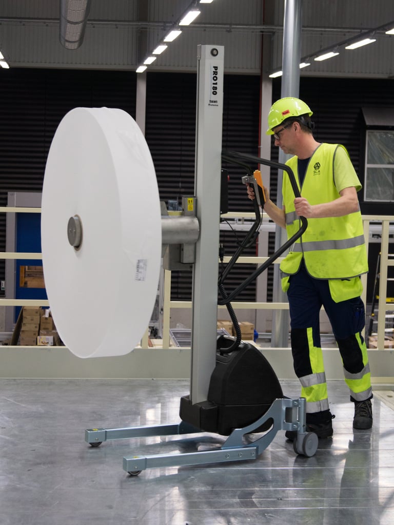 Homens manuseando bobinas nas instalações de produção da SCA