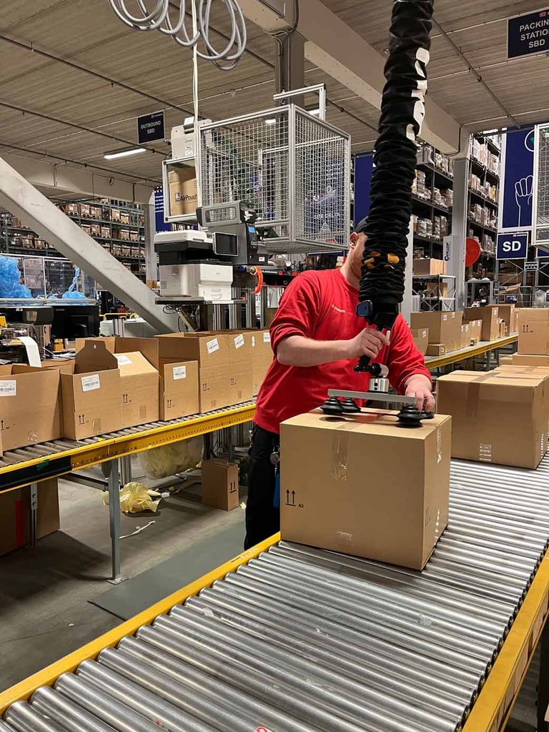 Warehouse worker at DB Schenker lifting boxes