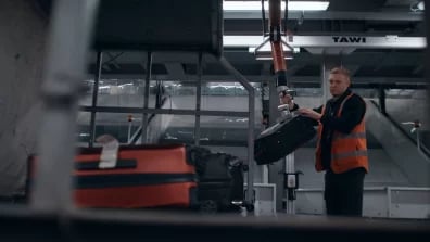 Worker at London Standsten Airport Lifting baggage with TAWI High-frequency lifter