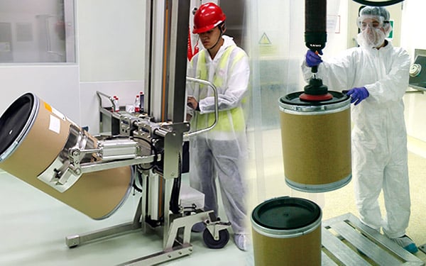 Operario elevando bidones en un laboratorio