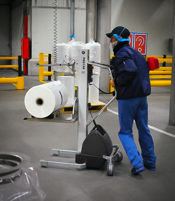 Operator in food packaging lifting rolls with TAWI reel lifting trolleys