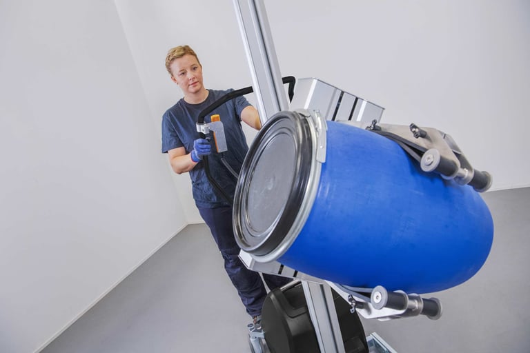 Woman lifting a large drum with TAWI ergonomic lifting trolley