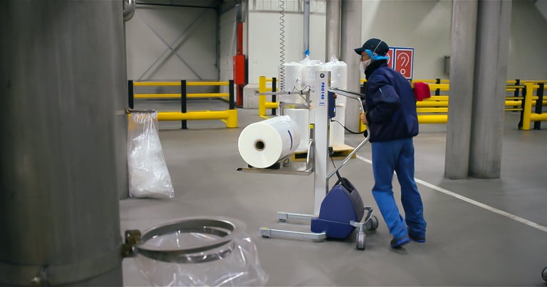 Operatore movimenta una bobina con un carrello di asservimento TAWI