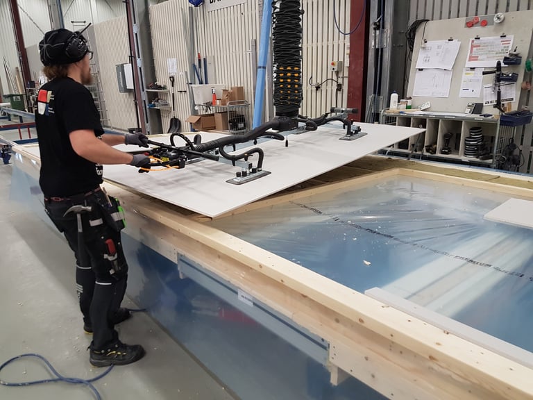 a worker lifting a wood panel with TAWI panel lifter