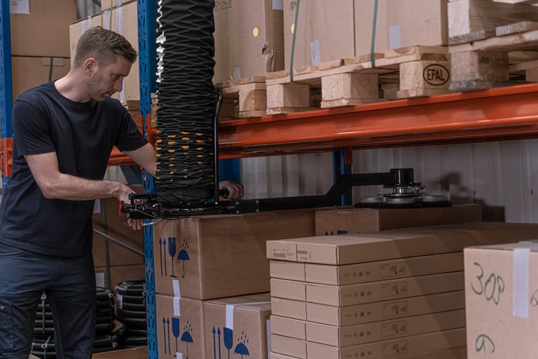 Easy Reach attachment on a TAWI Mobile Order Picker lifting boxes from warehouse shelving
