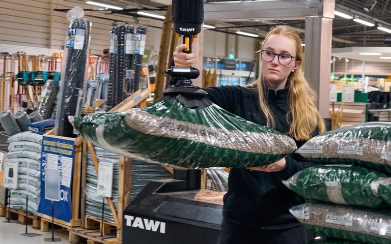Mobil Ordre Plukker løfter plastikpose op på palle.