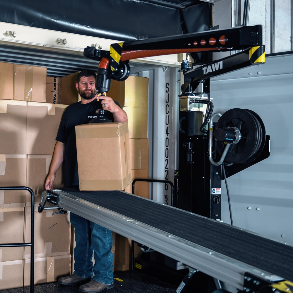 Operator devanning cardboard boxes from a truck using TAWI's Container Unloader