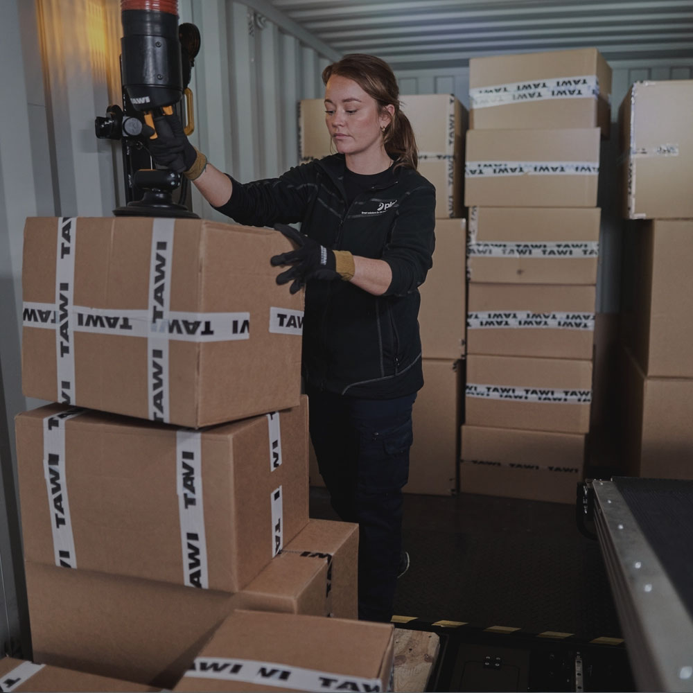 Woman unloading boxes from a truck using a vacuum lifter