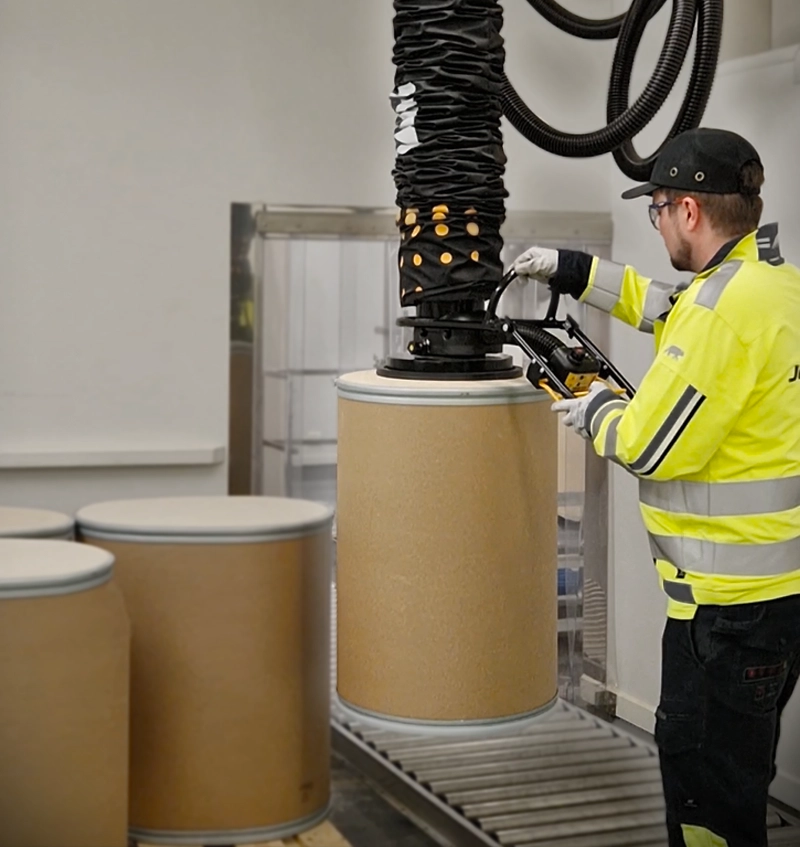 TAWI-oplossingen voor het hanteren van vaten in actie op de magazijnvloer. Zware dozen worden moeiteloos getild, waardoor de fysieke belasting voor de medewerker aanzienlijk wordt verminderd.