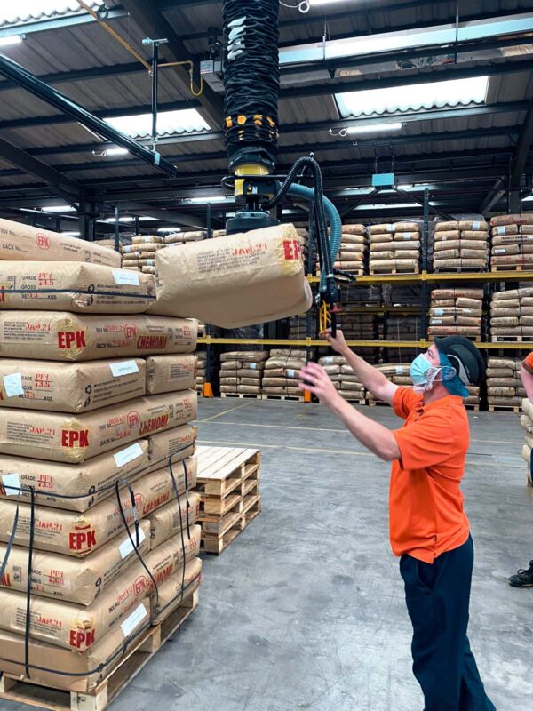 Man using a vacuum lift with an extended handle to lift sacks