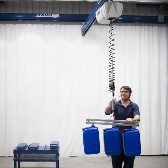 man lifting cannisters with wire hoist