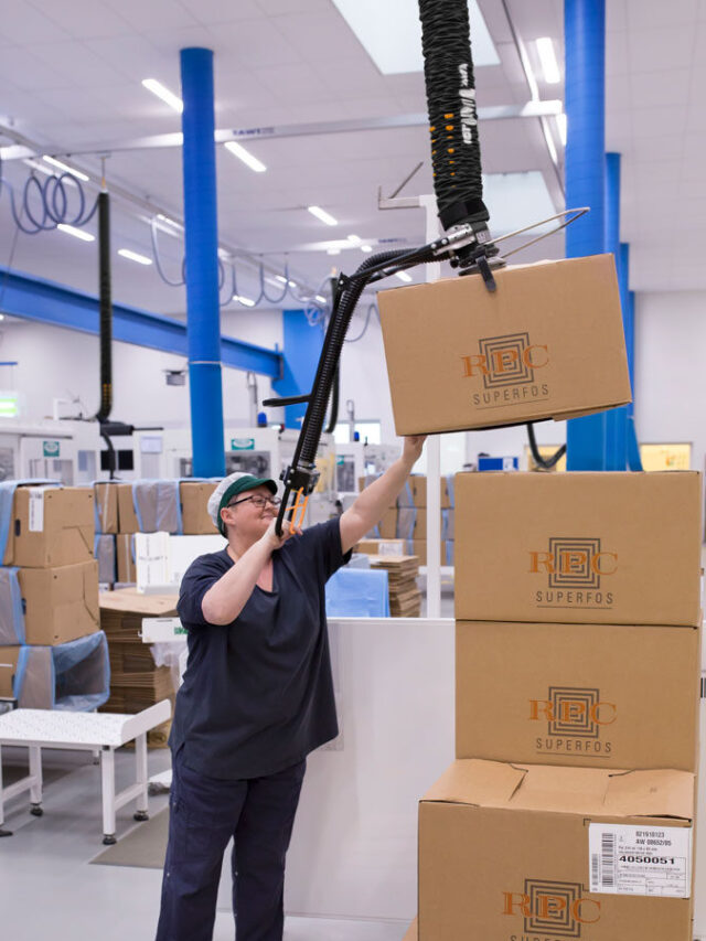 Woman lifting up and packaging boxes above her shoulder using a handhold vacuum lifter