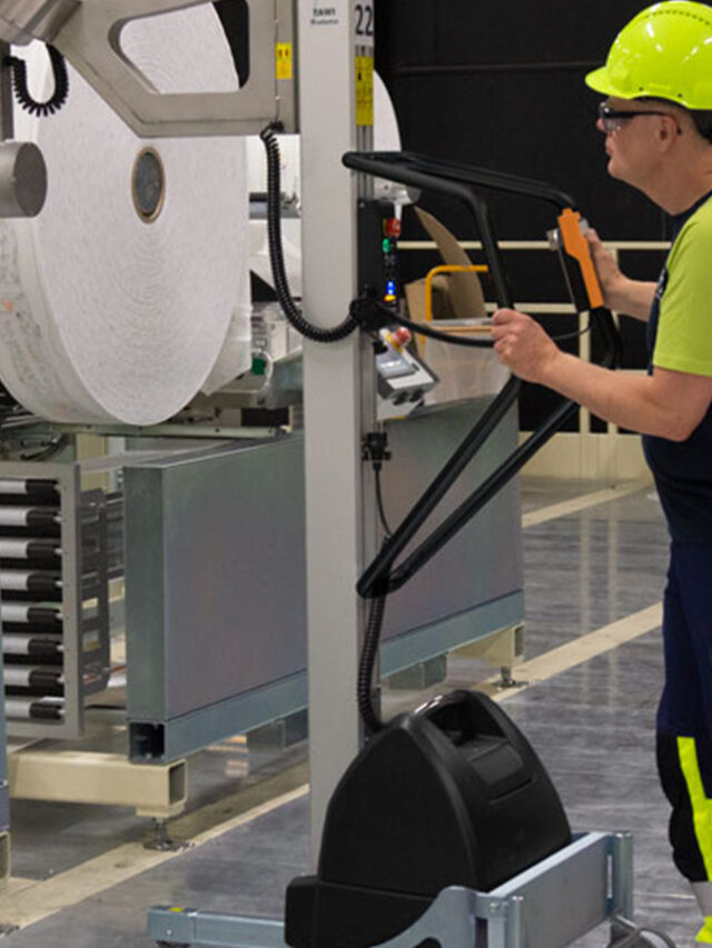 Man lifting and moving big plastic roll using a handhold vacuum lifter