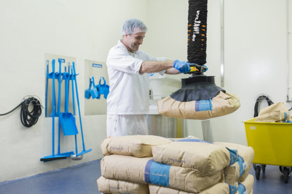 man lifting paper sack with food using handhold vacuum lifter