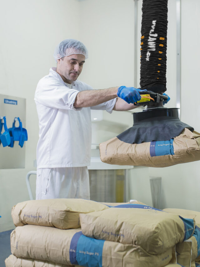 man lifting paper sack with handhold vacuum lifter