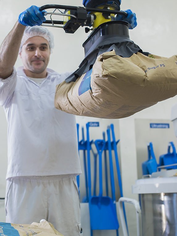 man lifting paper sack with vacuum lifter
