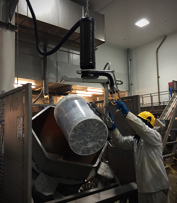 Man i fabrik häller metall i ett kärl med hjälp av en skräddarsydd vakuumlyft