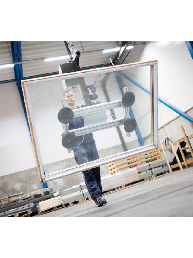 Man gripping and lifting big metal sheet using a handhold vacuum lifter system