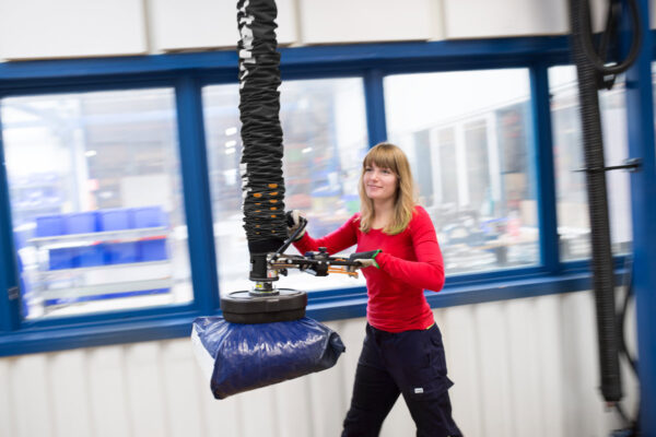 kvinna lyfter plastsäck med vakuumlyft
