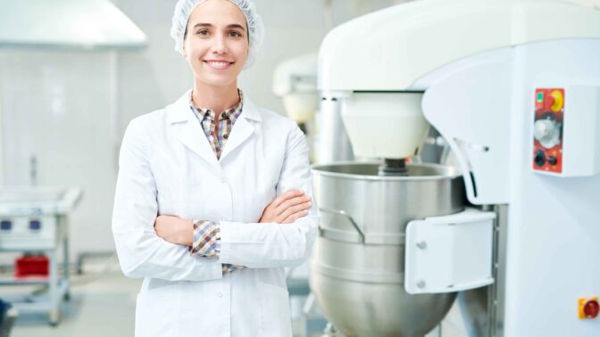 A smiling woman standing in a food industry environment