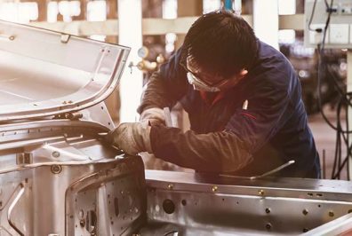 Man working on car chassi in awkward position