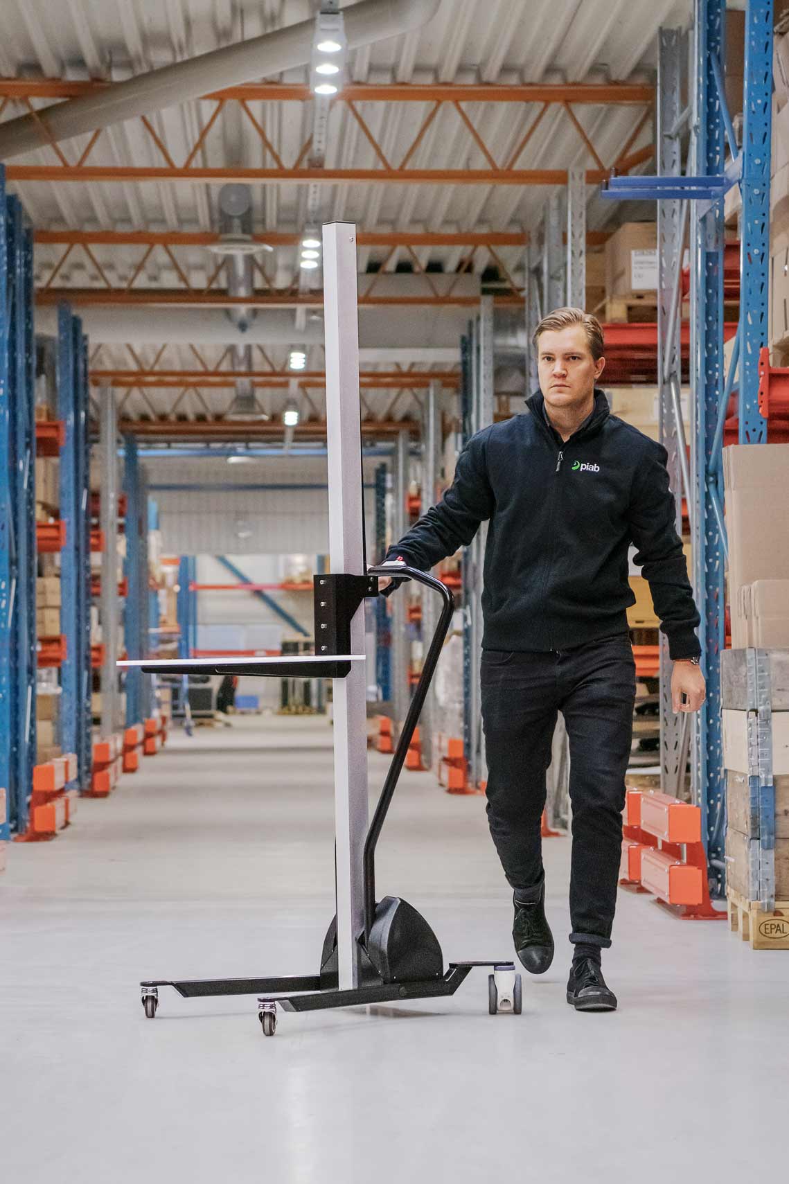 Man walking with a lifting trolley in a warehouse