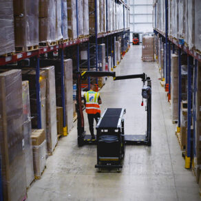 Personal på Yusen Logistics kör Containerlossare genom gång på lager