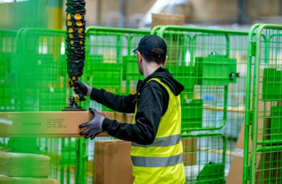 Man sorting boxes in cages with a TAWI vacuum lifter. Create a flexible workforce with TAWI
